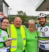 Mizen2Malin riders and supporters standing in a garage forecourt during the 2024 event