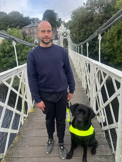 Donnacha standing on a bridge with Ulysses sitting beside him.