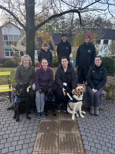 Group photo of the new Assistance Dog owners and their dogs and trainers