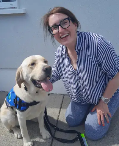 Eileen kneeling on a path with Tess sitting beside her