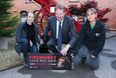 Minister for Justice Jim O'Callaghan kneeling down with Puppy Raising Supervisor Frances Rooney to his left, puppy raiser Joanna Doroszko and puppy in training Ruffles